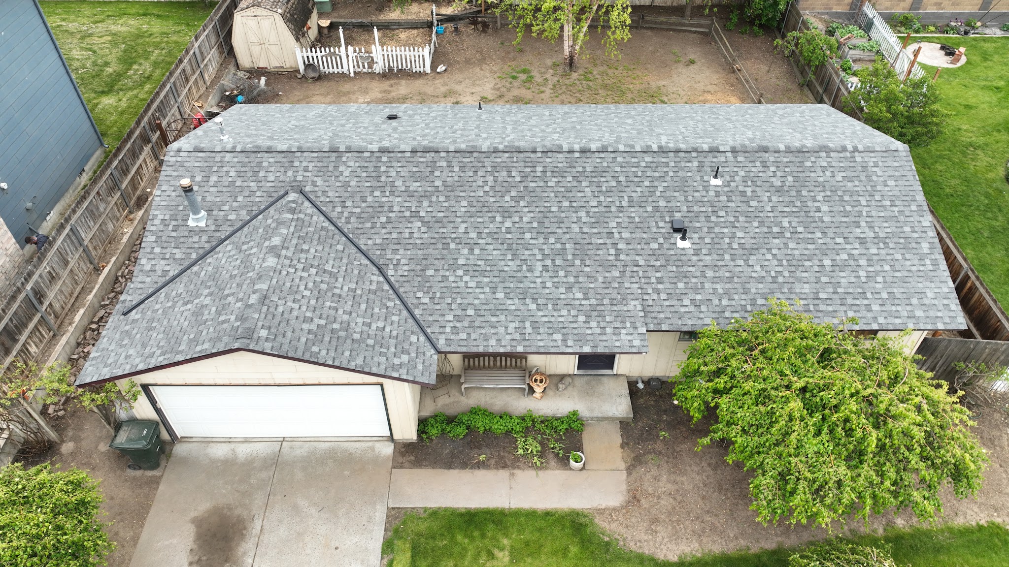 Aerial view of a finished shingle roof on a single story home with a garage and backyard shed